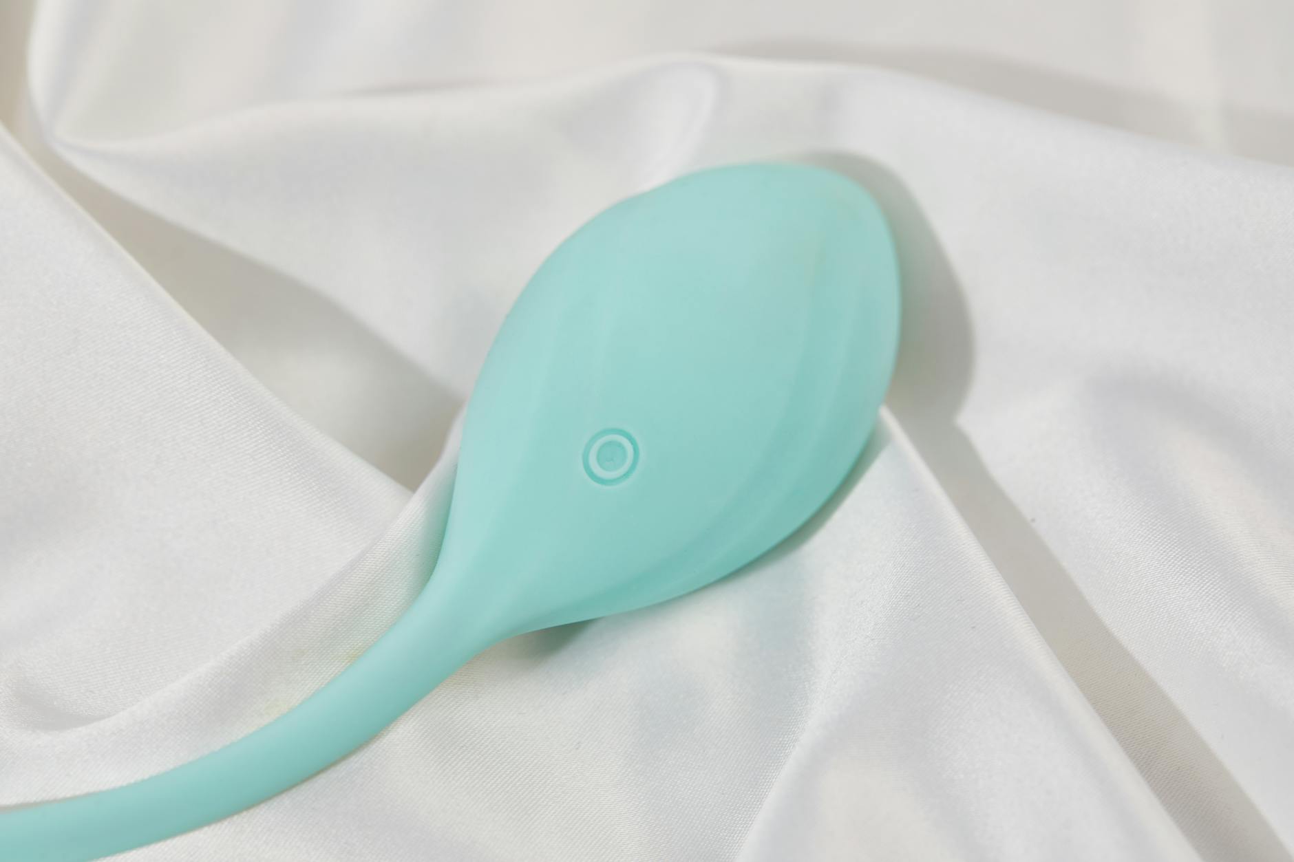 A lemon clitoral vibrator on soft white fabric, representing accessible pleasure for couples navigating ED.