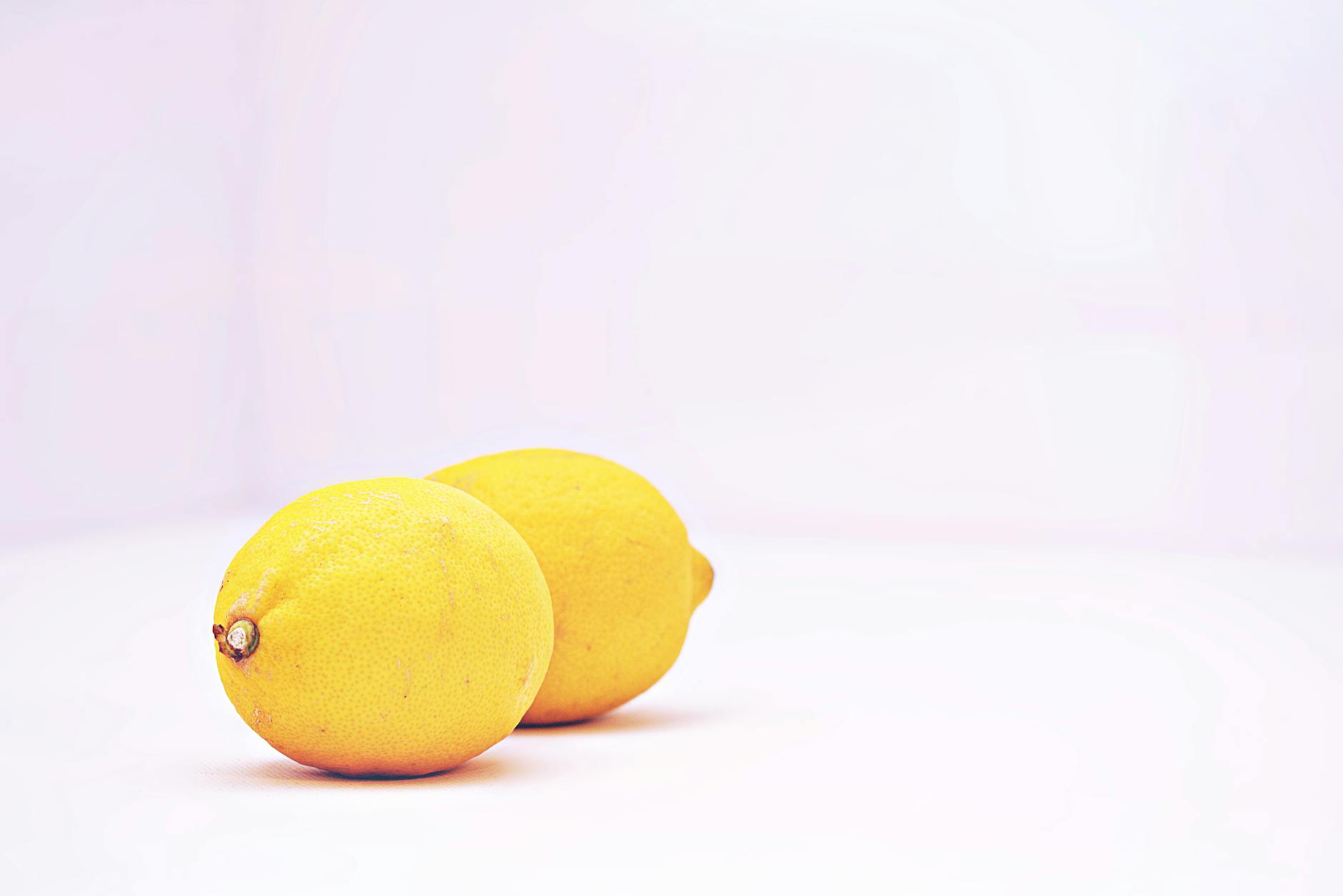 A hand holding an orange vibrator against a purple backdrop, showcasing modern sensuality and personal pleasure.