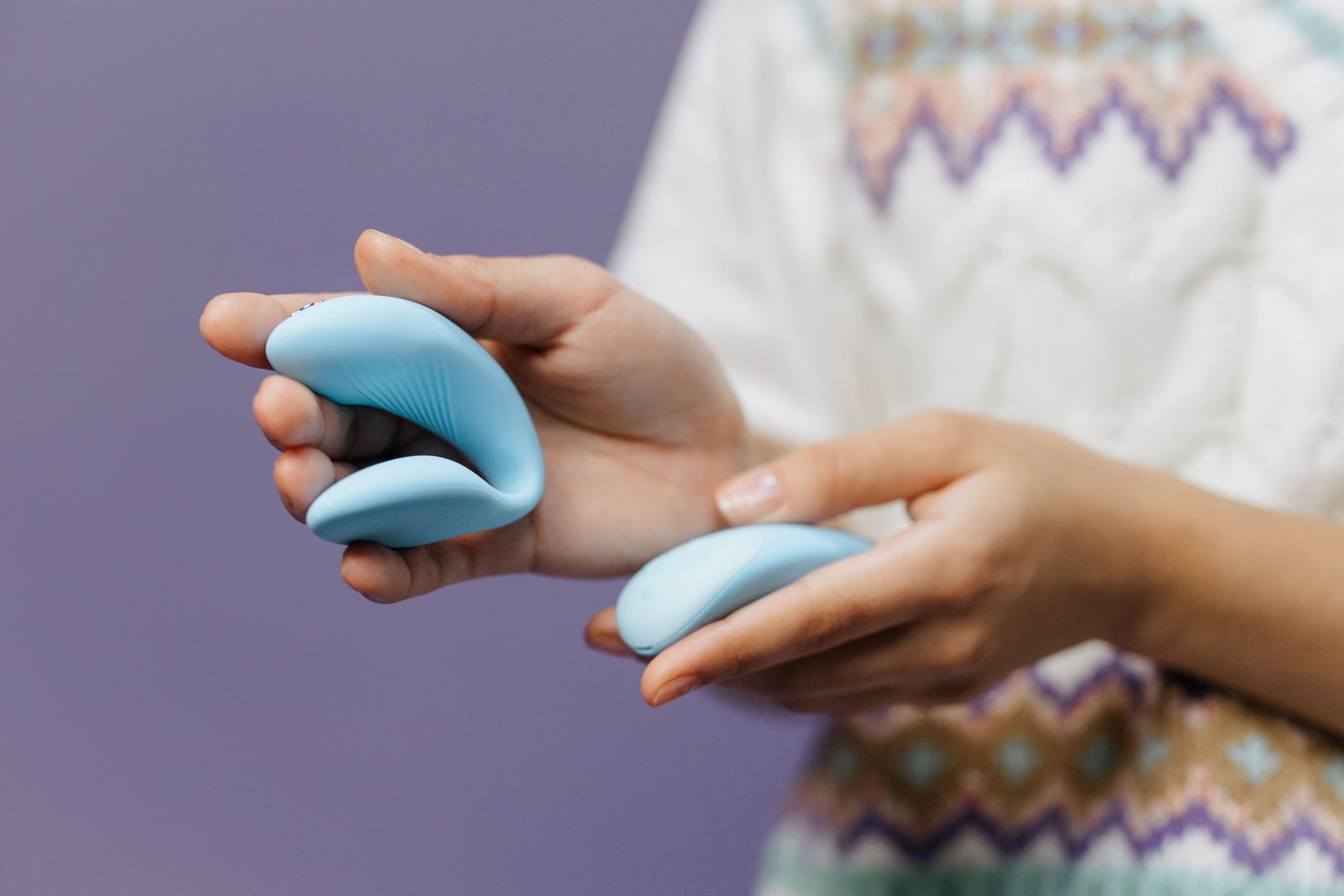 Hands holding a sleek clitoral vibrator, representing reconnection between body and emotion.